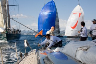 SAINT-TROPEZ, FRANCE - October 5th: The crew onboard the Wally maxi yacht Dangerous But Fun of Monaco owned by Michelle Perris prepare to gybe the yacht in front of Magic Carpet (blue spinnaker) and J One (white spinnaker) during racing on October 5th 2006. Dangerous But Fun crossed the finish in 2nd place. The largest classic and modern yachts from around the world gather in Saint-Tropez annually for a week of racing and festivities to mark the end of the Mediterranean season, before heading across the Atlantic to winter in the Caribbean.