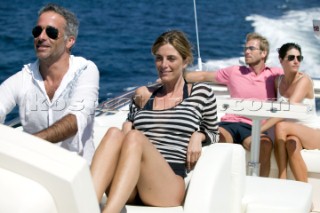 Four people sitting on top of yacht enjoying themselves.