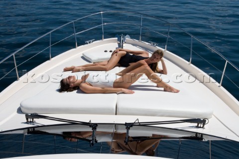 Two women sunbathing on powerboat