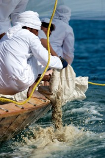 LOUIS VUITTON TROPHY, DUBAI, UNITED ARAB EMIRATES, NOVEMBER 20TH 2010: The crew participating in a traditional dhow race. Releasing sand ballast. Louis Vuitton Trophy in Dubai (12 - 27 November 2010).