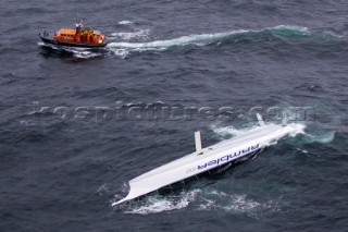 Rambler 100, Sail n: USA25555, Class: IRC CK, Division: IRC, Owner: George David, Type: JK 100.  George Davids RAMBLER 100 capsized and the crew being rescued by the Baltimore RNLI lifeboat.  Rolex Fastnet Race 2011.