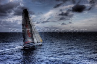 The canting keel maxi yacht Alfa Romeo offshore in a storm with clouds and stormy sky during the La Giraglia Race