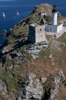 Yachts rounding the Giraglia Rock Lighthouse on the island in the MEditerranea