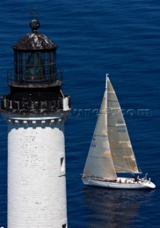 Yachts rounding the Giraglia Rock Lighthouse on the island in the Mediterranean