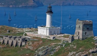 Yachts rounding the Giraglia Rock Lighthouse on the island in the Mediterranean