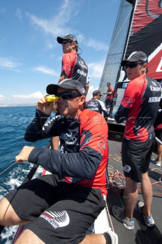 Emirates Team New Zealand tactician Ray Davies takes bearings with a hand bearing compass to the sta