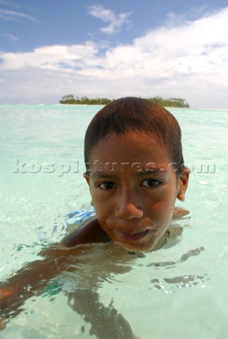 A young boy plays in the water off Honeymoon Island Cook Islands South Pacific