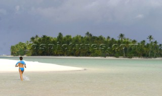 Walking though the clear water of Onefoot Island, Cook Islands, South Pacific. 31. Mar 2003.