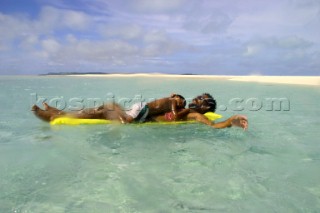 Father and son relax off Honeymoon Island, Cook Islands, South Pacific. 31. Mar 2003.