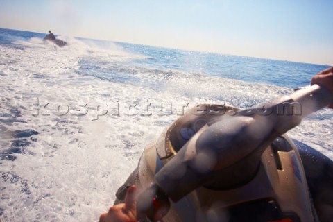 Two men jet skiing in the mediterranean sea