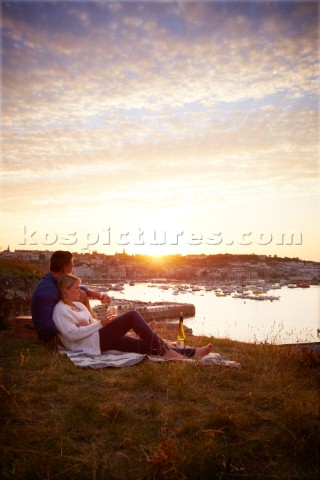 Couple relaxing on blanket in the sunset