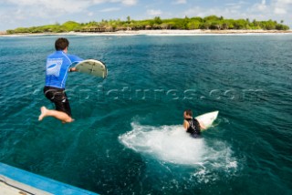 Surfers leaping into the ocean off a dhoni (traditional Maldivian boat) at the start of a surf session at the surf break known as Lohis at Lhohifushi Island, North Male (Kaafu) Atoll, Maldives, on the 7 November, 2006. The Maldives is a popular destination for surfers with consistent waves and wind from April to November each year.