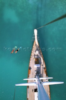 An aerial view from atop the masthead of Sincerity  a classic yacht, looking down at two snorkelers alongside,far below.  Taken on Green Island, Antigua, British West Indies, a popular sailing destination.