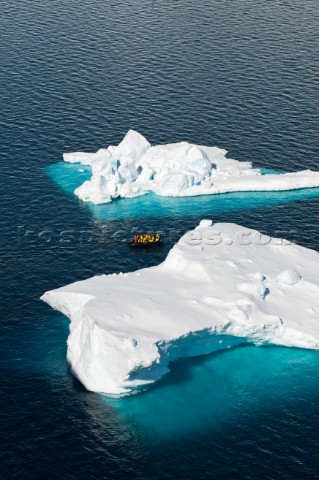 Tourists on a motorized inflatable raft known as a zodiac cruising amongst icebergs Paradise Harbor 