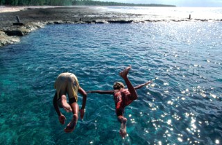 On the shores of Nukatavaki, children celebrate the arrival of the cargo ship with a dive into the loading bay.