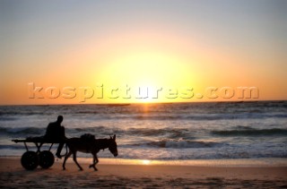 Mauritania October 27, 2006 - A donkey cart, acting as a local taxi, travels along a beach in Nouakchott. Donkey carts are used in Mauritania to carry loads and to taxi local people. ( Jean-Michel Clajot / Aurora Photos )