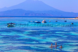 People travels by SUP surfboards at coastline of Nusa Lembongan and Nusa Ceningan islands, Indonesia.