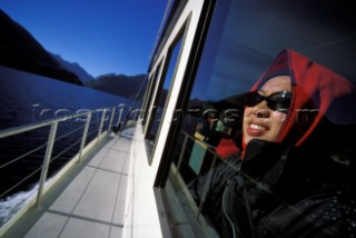 Hanh Quach looks through a viewing glass on a sightseeing boat in the Doubtful Sound, Fiordland National Park, New Zealand. Doubtful Sound is the second largest fiord out of the 14 in the park. On any given day you can see dolphins and porpoises jumping and playing about in the sound.