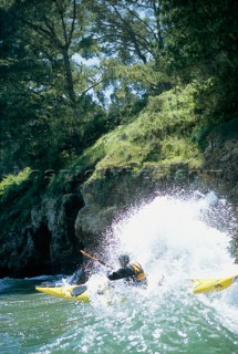 Sea kayak guide Josh Mendenhall punches through a wave on a surf launch in San Simeon along the central coast of California.