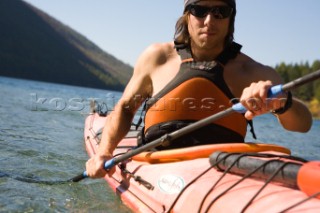 Man kayaking Kintla Lake during two day backpack loop trip through heart of Glacier National Park, MT near Hole-in-the-Wall area -  Greg Franson.