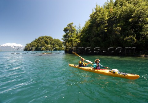 Anastacia Kampe  and Ben Sanders sea kayak during a wilderness adventure in Lago Yelcho Chile