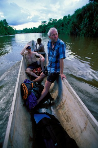 Stephen Koch and Rob Milne catch a ride in a wooden canoe on their way to climb Carstensz Pyramid wh