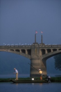 Fly fishing guide Mike Obrien and Cathy Beck enjoy some summer smallmouth bass fishing on the west branch of the Susquehanna River in Pennsylvania on July 10, 2003. In the background is the Milton Bridge decorated with American flags.