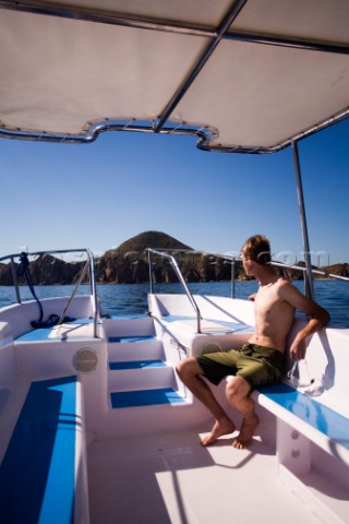 A man rides on a tour boat in Cabo San Lucas Mexico  releasecode 20071103SamWellsjpg