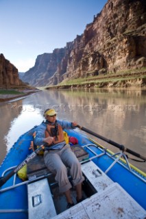 Dana Johnson paddling an inflatable raft down Cataract canyon, Colorado river, Utah. Photo taken during a raft trip down the Colorado river from Moab to Lake Powell through Canyonlands National Park and Cataract canyon, Utah.