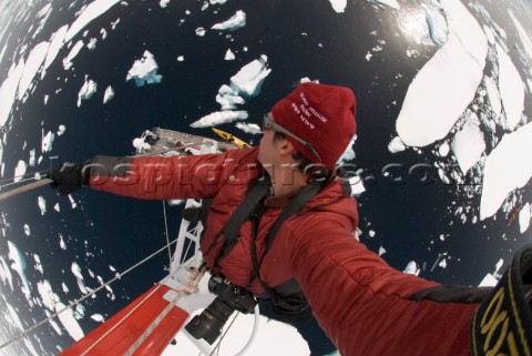 Man shoots a picture of himself as he climbs the mast of a ship in Antarctica and looks down from a 