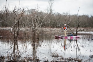 Angler standing up in his kayak and doing some fishing