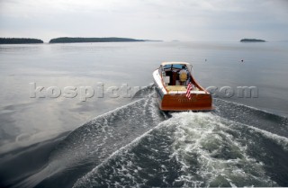 Power boat Gemma heads for home on calm seas. Islands dot the horizon and lobster buoys are sprinkled across the water on a gray day  in Penobscot Bay, Maine, USA  Model and Property Release:RP07011_Gemma_JamesBrady  RM07007_JamesBrady