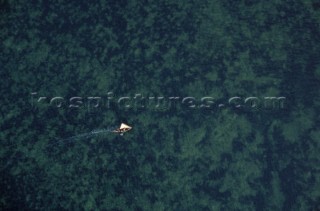 Aerial view of a fishing dhow sailing in shallow water near Kiwayu island off the northern coast of Kenya.