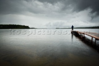 A man stands on the pier on Gregoire Lake. Without the huge amount of fresh water resources in Northern Alberta, the Tar Sands would not be able to operate. Ironically, the oil companies dont pay anything for the water removed from the Athabasca, which they subsequently pollute, requiring residents downstream to buy bottled water to drink.