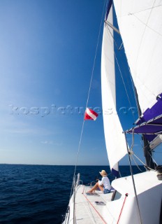 Ambergris Cay, Belize. A woman sits on the front of a catamaran while enjoying a cruise on the deep blue waters of the Caribbean. Michael Hanson/Aurora Photos/Kos Pictures