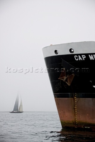 J Class fleet racing in Falmouth 2012 past the bow of a commercial ship